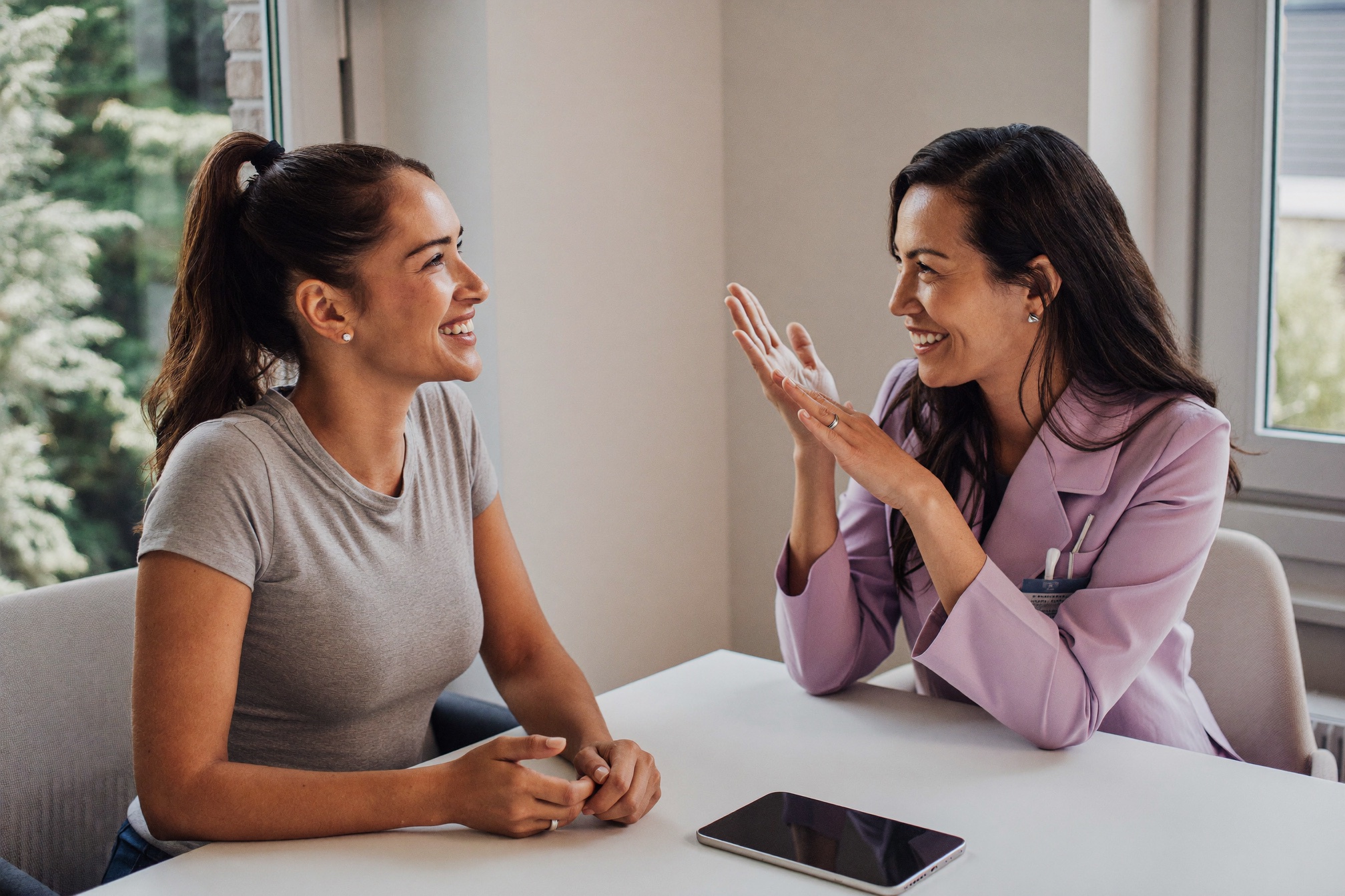 A woman reviewing a simple one-area plan with her surgeon on a tablet in a bright consultation room