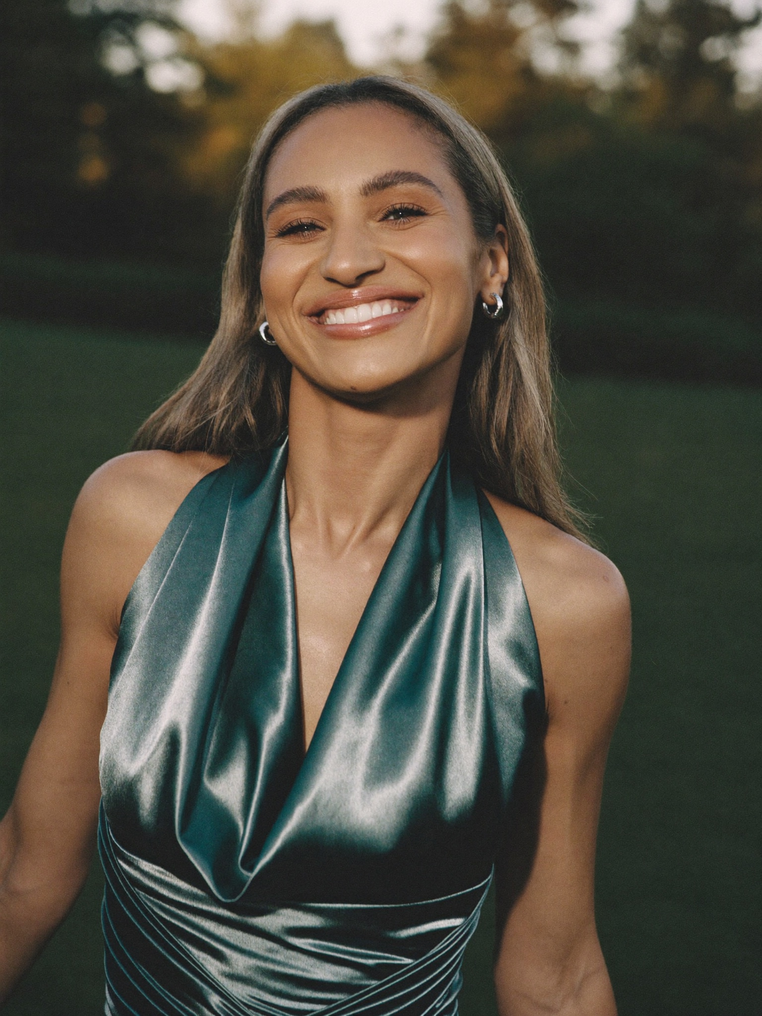 A confident woman in a sleeveless dress, at ease some time after her one-area arm lift