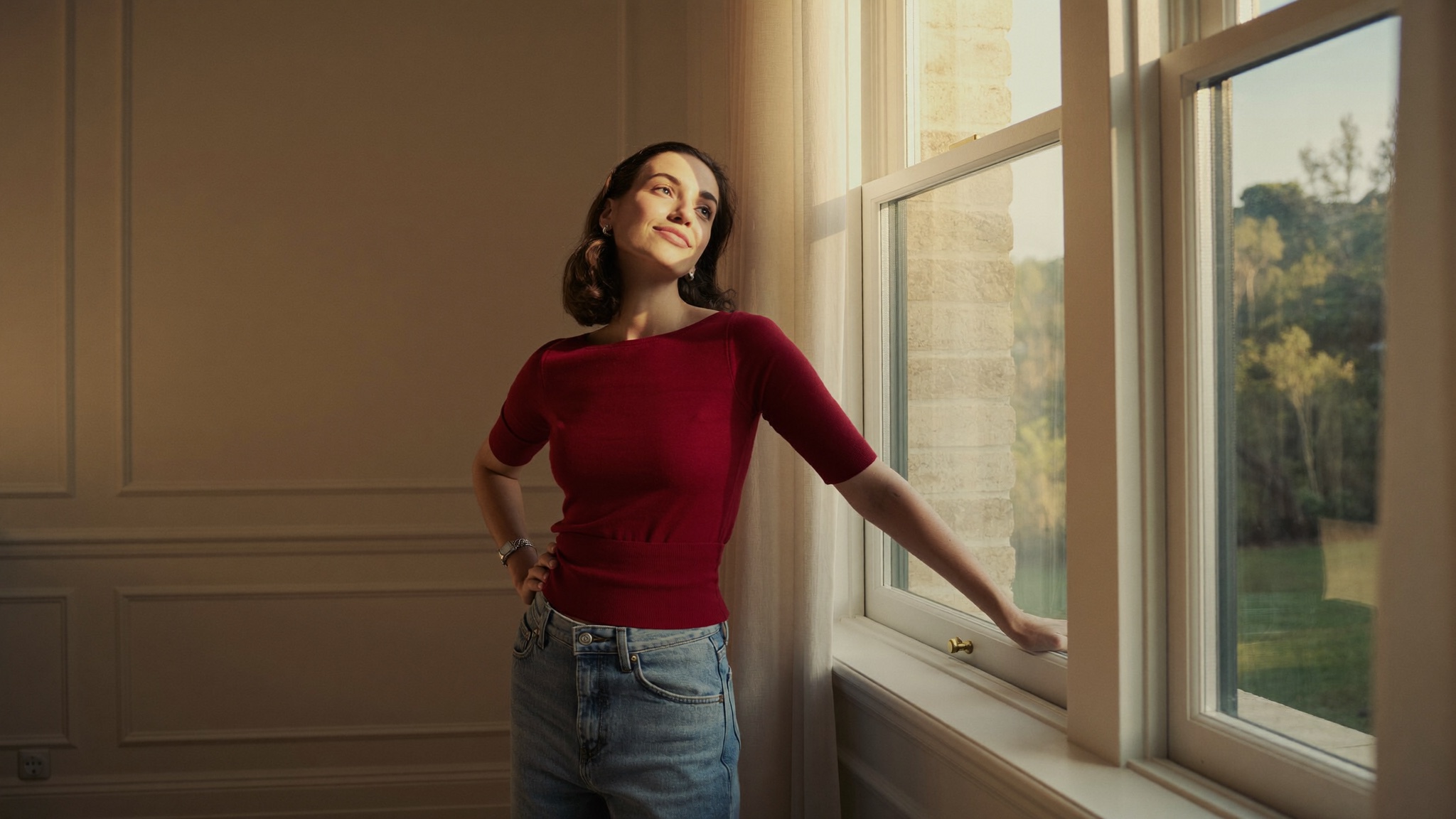 A poised, at-ease woman in warm light, comfortable and confident